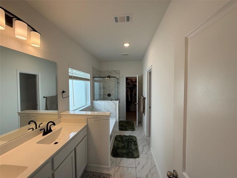 Double vanity with integrated sinks and black matte faucets, under-mount cabinetry, and a large mirror