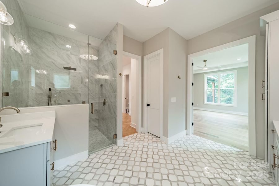 Your stunning Master Suite boasts beautiful custom lighting, cabinetry, tilework, a soaking tub, and a spacious shower.