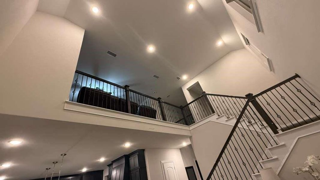 Stairway with a towering ceiling and recessed lighting