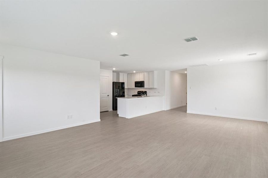 Unfurnished living room with light wood finished floors and recessed lighting Unfurnished living room with light wood finished floors and recessed lighting