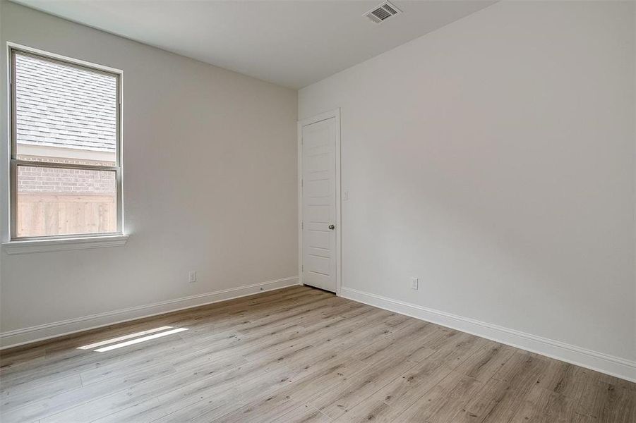 Spare room featuring a wealth of natural light and light wood-type flooring