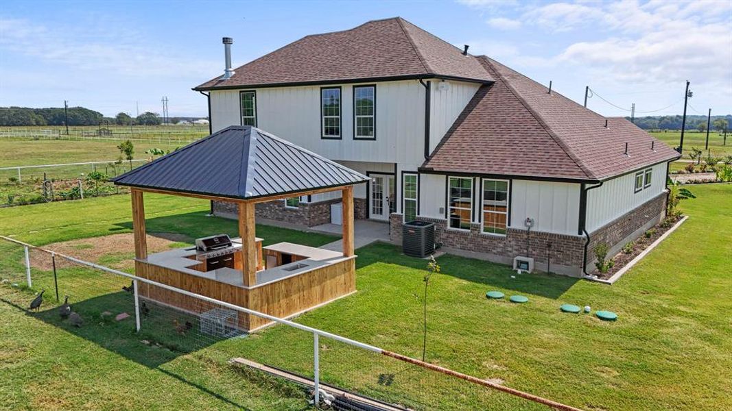 Back of property with a patio, a gazebo, a shingled roof, and brick siding Back of property with a patio, a gazebo, a shingled roof, and brick siding