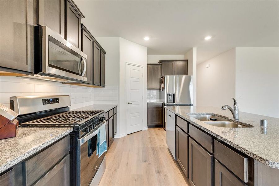 Ranch-style house featuring concrete driveway, a front lawn, brick siding, an attached garage, and roof with shingles Ranch-style house featuring concrete driveway, a front lawn, brick siding, an attached garage, and roof with shingles
