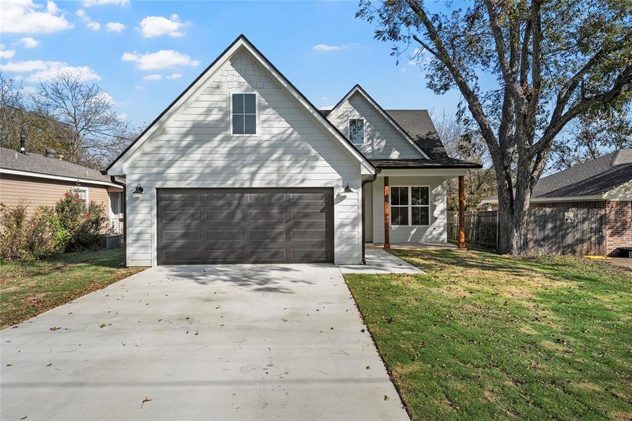 Traditional-style house featuring driveway, a garage, and covered porch Traditional-style house featuring driveway, a garage, and covered porch