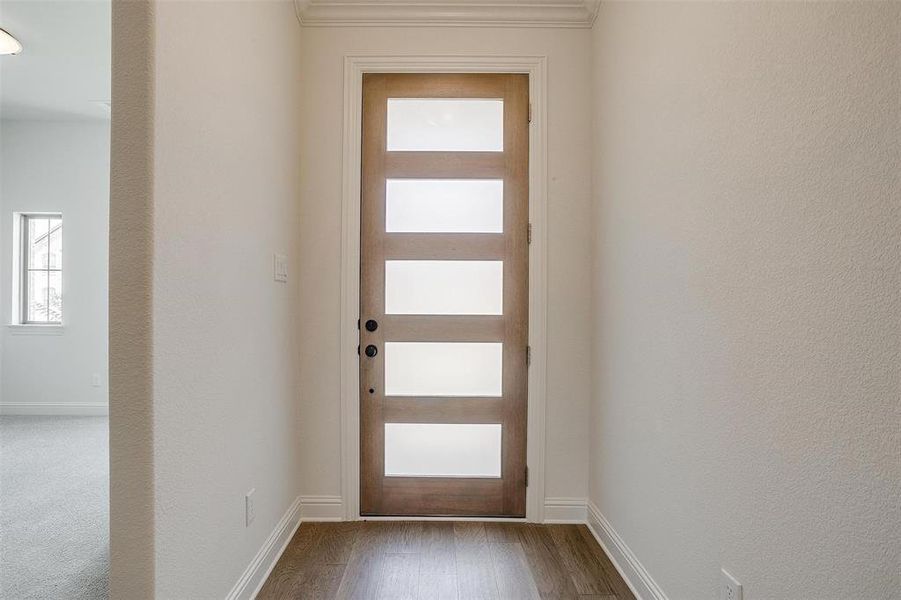 Entryway featuring crown molding and hardwood / wood-style floors