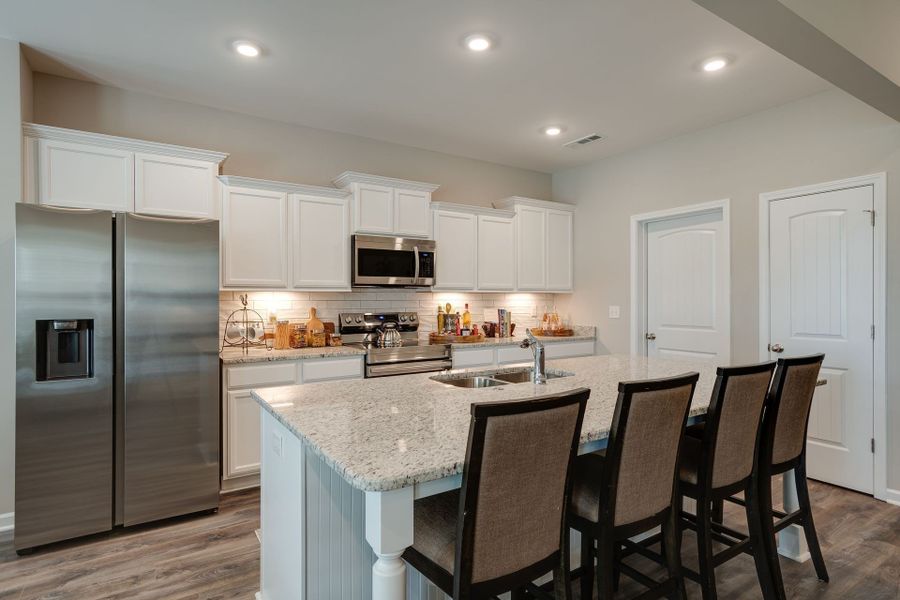 Stock photo showing island and kitchen set up. Your home will have white cabinets and coordinating QUARTZ countertops. Stock photo showing island and kitchen set up. Your home will have white cabinets and coordinating QUARTZ countertops.