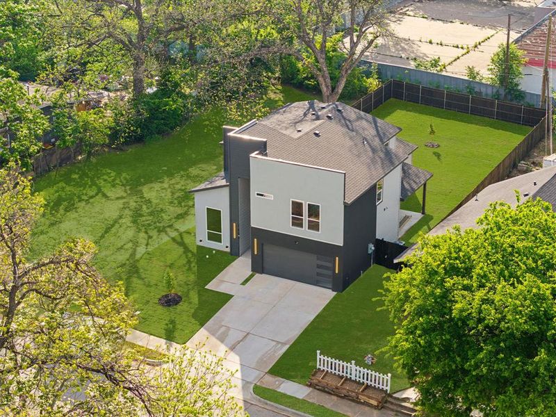 The property features a contemporary exterior with a dark gray and light gray facade, a well-maintained lawn surrounding the home, and a dark asphalt shingle roof The property features a contemporary exterior with a dark gray and light gray facade, a well-maintained lawn surrounding the home, and a dark asphalt shingle roof