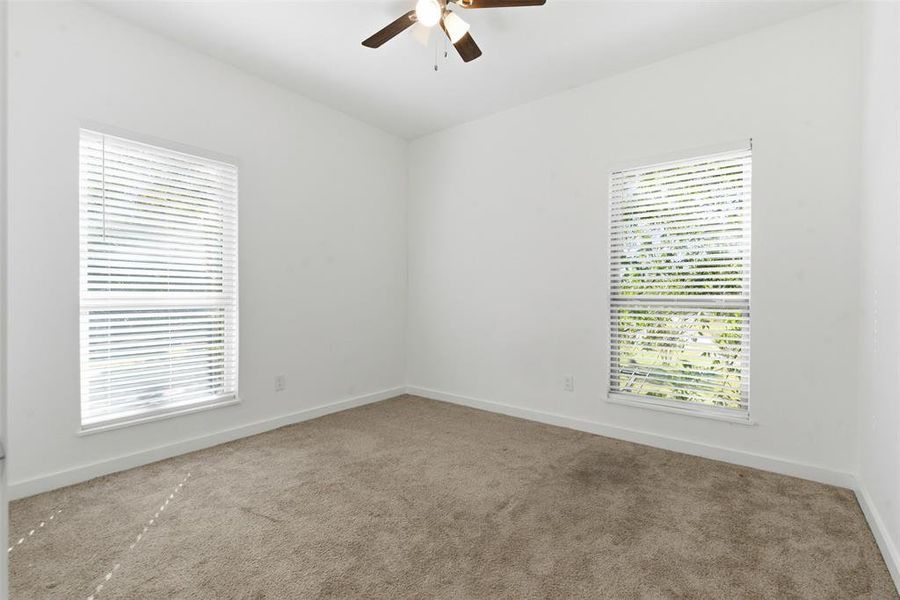 Carpeted spare room with baseboards and a ceiling fan Carpeted spare room with baseboards and a ceiling fan