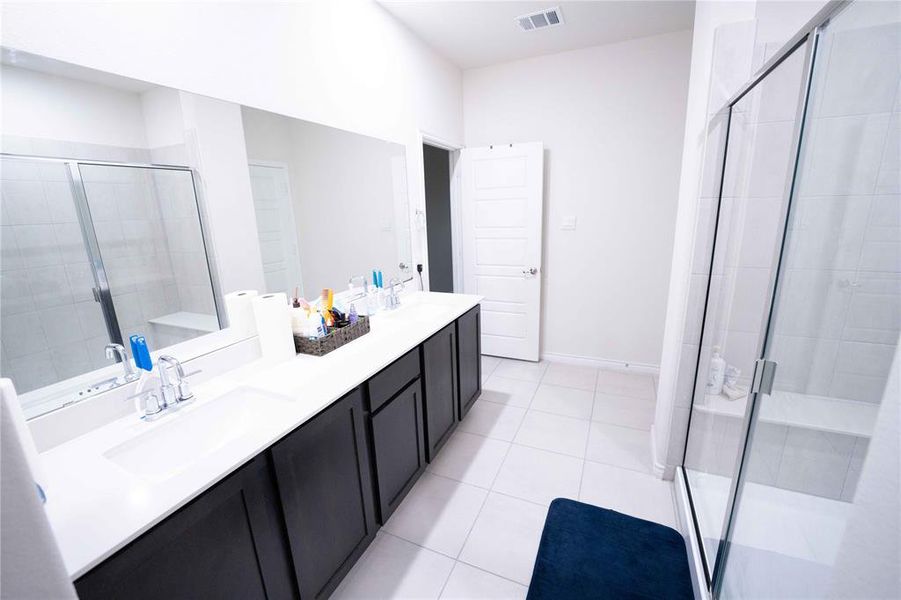 Dual sink vanity with dark wood-finish cabinetry and white countertops Dual sink vanity with dark wood-finish cabinetry and white countertops