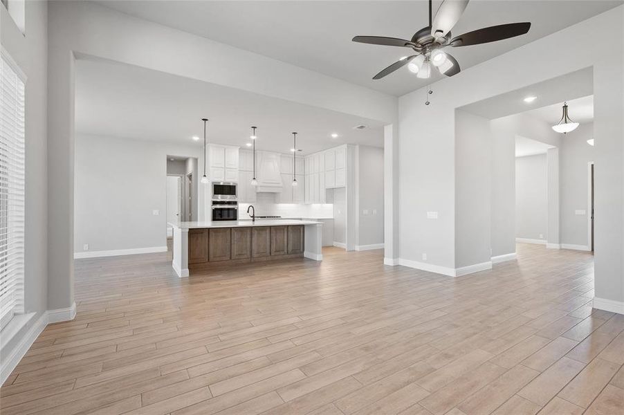 Unfurnished living room with recessed lighting, ceiling fan, and light wood-style floors