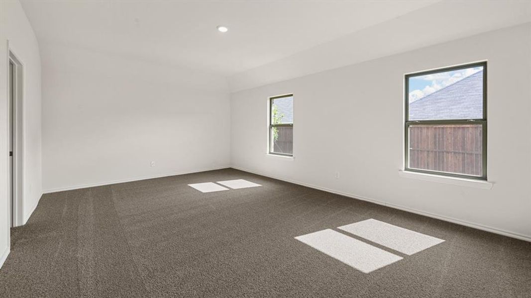 Spacious room featuring neutral carpeting, white walls, and multiple windows Spacious room featuring neutral carpeting, white walls, and multiple windows