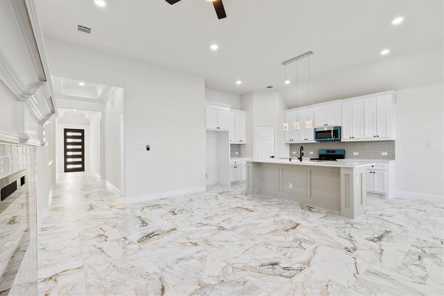 Kitchen with visible vents, decorative backsplash, stainless steel appliances, white cabinetry, and a sink Kitchen with visible vents, decorative backsplash, stainless steel appliances, white cabinetry, and a sink