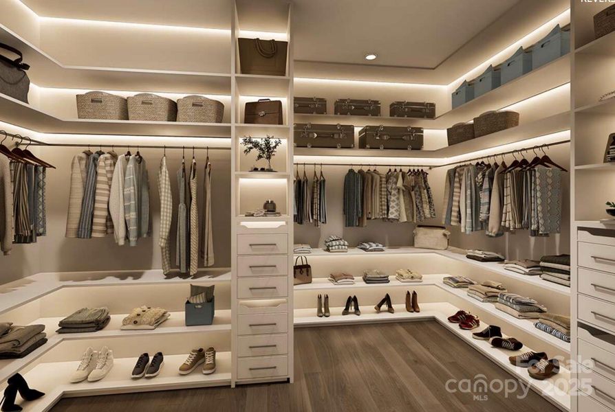 This expansive walk-in closet offers a boutique-style layout with custom built-ins, open shelving, and ample hanging space for effortless organization. This expansive walk-in closet offers a boutique-style layout with custom built-ins, open shelving, and ample hanging space for effortless organization.