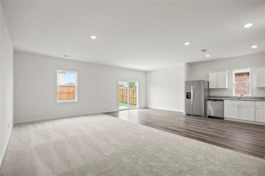 Bright central living space anchored by expansive wall space and easy connection to dining and kitchen.