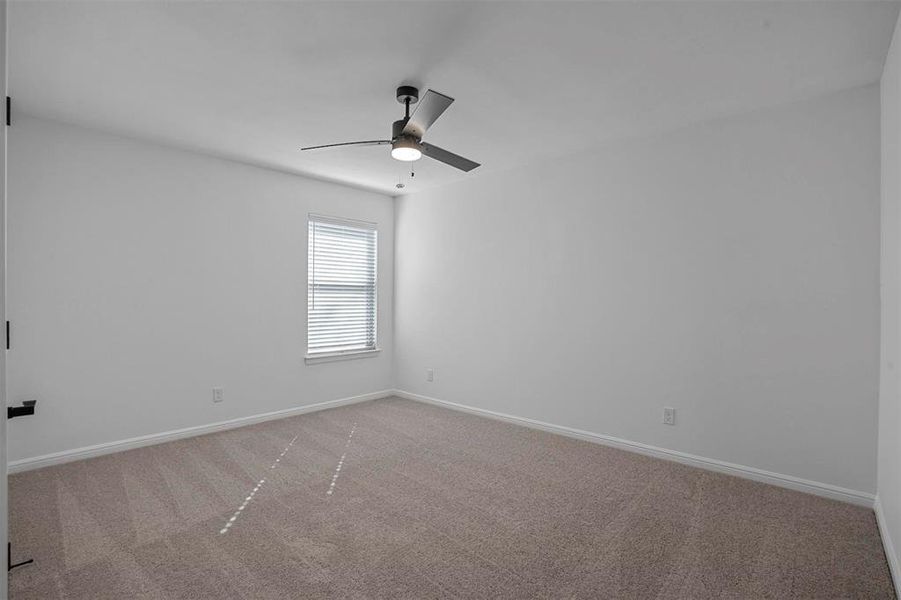 Unfurnished room with ceiling fan and light colored carpet