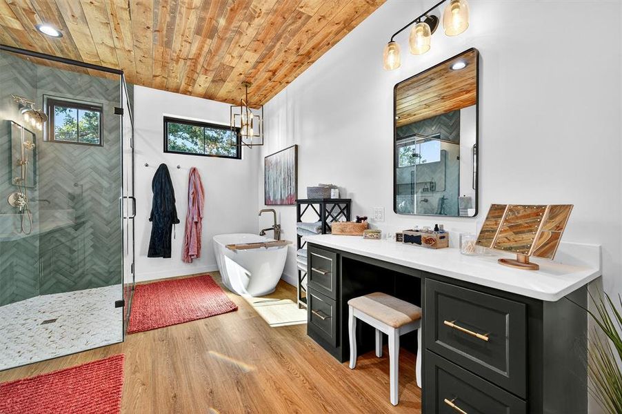 Bathroom with a shower stall, a freestanding tub, light wood-style flooring, wood ceiling, and vanity Bathroom with a shower stall, a freestanding tub, light wood-style flooring, wood ceiling, and vanity