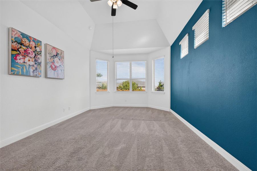 A vaulted ceiling and bay window define this comfortable carpeted bedroom. A vaulted ceiling and bay window define this comfortable carpeted bedroom.