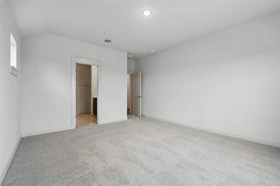 Unfurnished bedroom with light colored carpet and ensuite bathroom Unfurnished bedroom with light colored carpet and ensuite bathroom