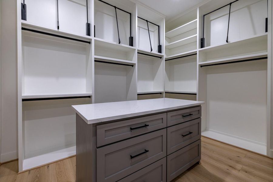 Boutique-style closet island with additional drawers and display space for elevated organization.