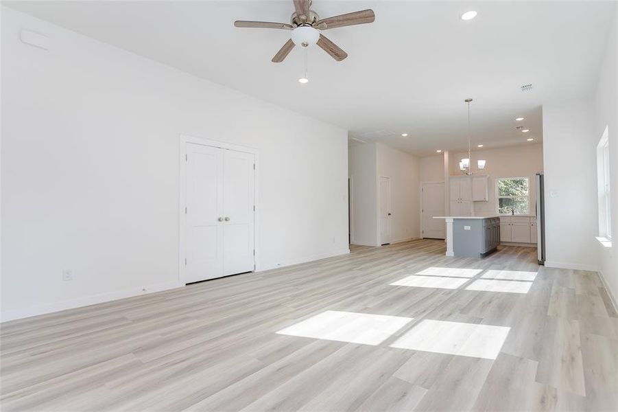 Unfurnished living room featuring light hardwood / wood-style flooring and ceiling fan