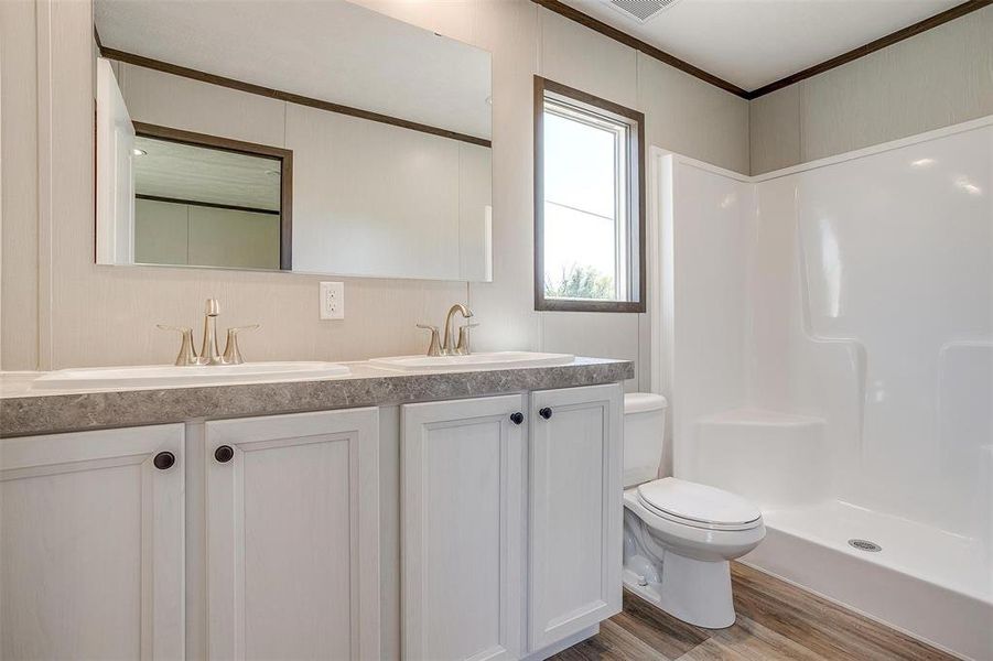 Primary bathroom with dual sinks, large shower and walk in closet.