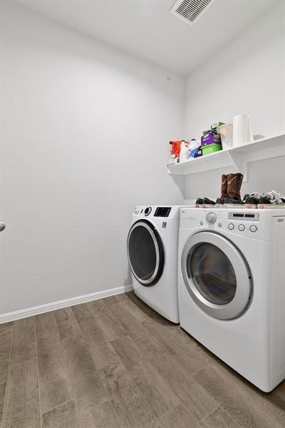 Laundry room featuring wood finished floors and washer and clothes dryer