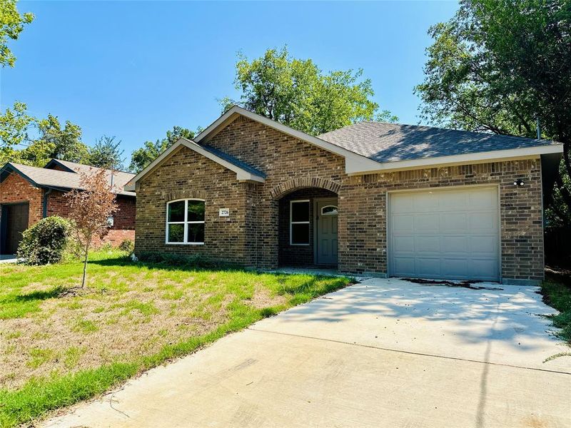 Ranch-style home featuring a garage and a front lawn