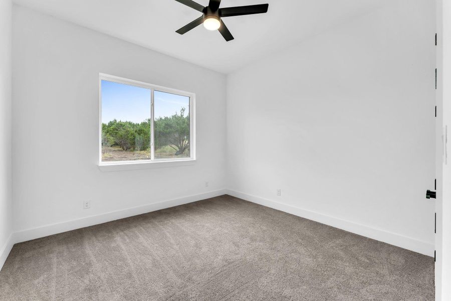 Empty room with light carpet and ceiling fan