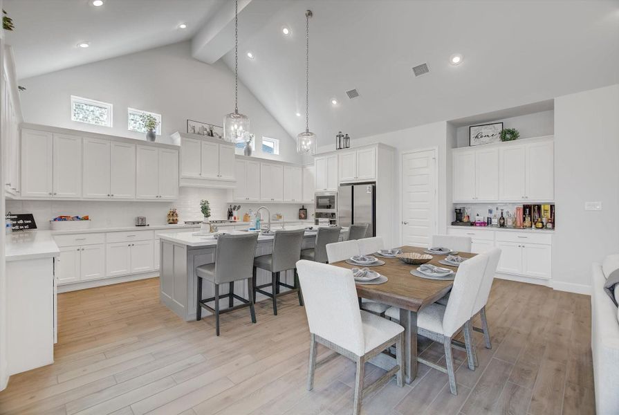 The dining area also includes a stylish coffee/bar nook with abundant cabinet storage, creating a perfect spot for morning brews, evening cocktails, or extra serving space when entertaining.