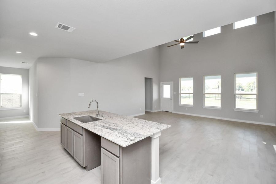 The open concept effortlessly connects the kitchen to the expansive family room, forming a perfect hub for gatherings. Sample photo of completed home with similar floor plan. Actual colors and selections may vary.