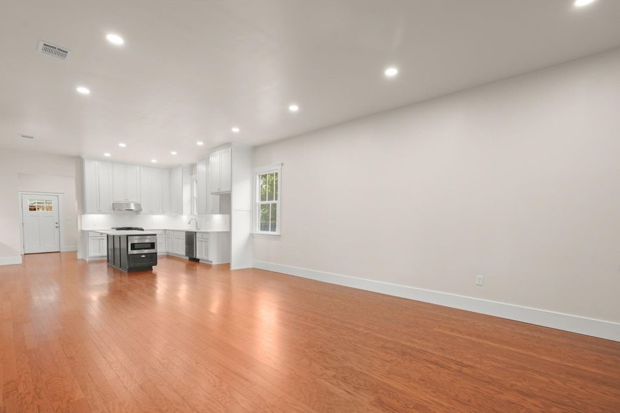 A contemporary open-concept space features warm hardwood floors and a sleek, well-appointed kitchen. A contemporary open-concept space features warm hardwood floors and a sleek, well-appointed kitchen.