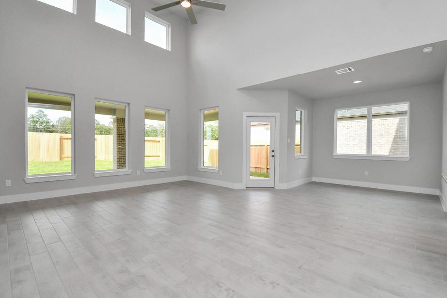 Gather the family and guests together in your lovely living room! Featuring soaring high ceilings, recessed lighting, ceiling fan, custom paint, gorgeous floors, and large windows that provide plenty of natural lighting throughout the day. Sample photo of completed home with similar floor plan. Actual colors and selections may vary. Gather the family and guests together in your lovely living room! Featuring soaring high ceilings, recessed lighting, ceiling fan, custom paint, gorgeous floors, and large windows that provide plenty of natural lighting throughout the day. Sample photo of completed home with similar floor plan. Actual colors and selections may vary.
