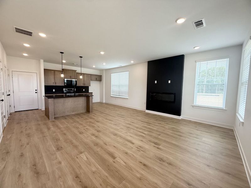 Kitchen featuring stainless steel appliances, open floor plan, dark countertops, recessed lighting, and light wood-style floors