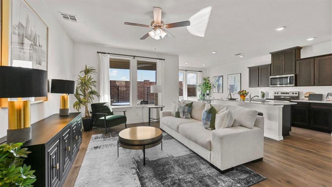 Living room featuring dark wood-style floors, ceiling fan, and recessed lighting