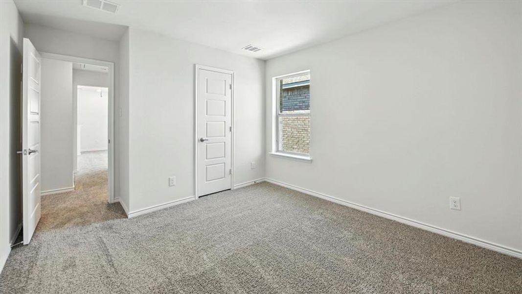 Unfurnished bedroom with carpet floors and baseboards