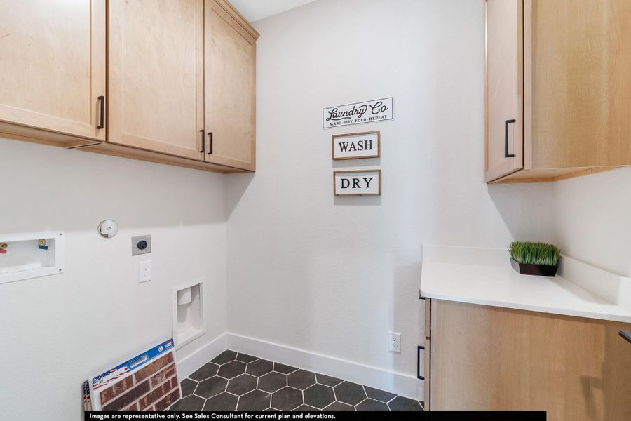 Laundry room with gas dryer hookup, dark tile patterned flooring, electric dryer hookup, cabinet space, and hookup for a washing machine Laundry room with gas dryer hookup, dark tile patterned flooring, electric dryer hookup, cabinet space, and hookup for a washing machine