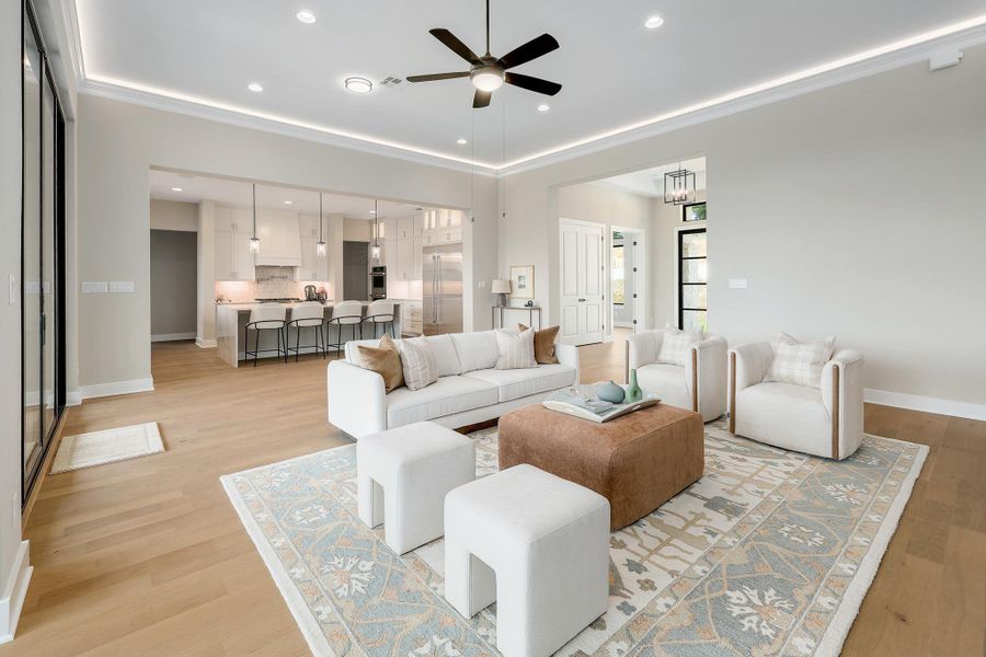 An inviting open-concept living space features light wood flooring and recessed lighting throughout.
