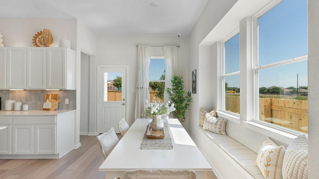 Sun-filled dining area features a cozy built-in window bench, perfect for enjoying morning meals. Sun-filled dining area features a cozy built-in window bench, perfect for enjoying morning meals.
