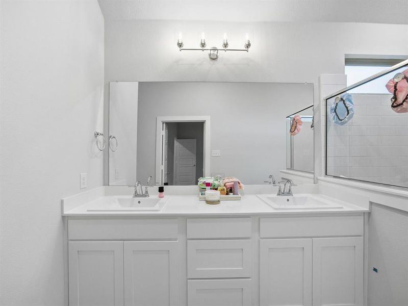 Full bathroom with double vanity and a tile shower