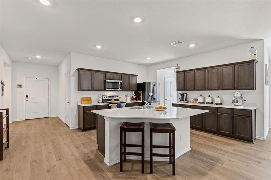 Open concept kitchen with large center island, quartz countertops, stainless steel appliances, and abundant cabinet space. Open concept kitchen with large center island, quartz countertops, stainless steel appliances, and abundant cabinet space.