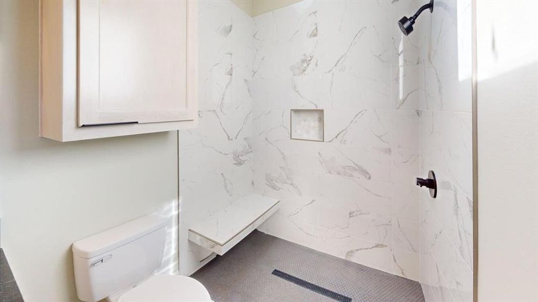 Bathroom with toilet and a marble finish shower