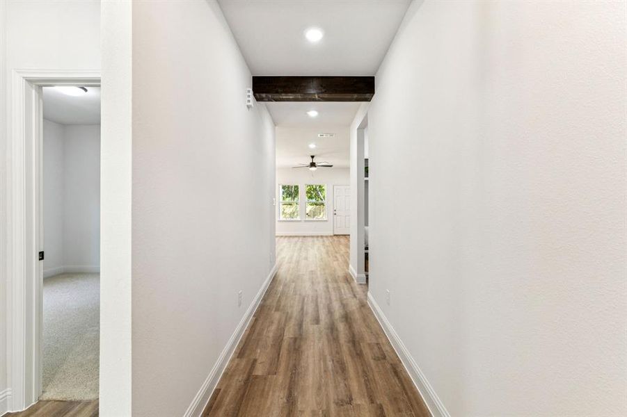 Corridor featuring beamed ceiling, wood finished floors, and recessed lighting