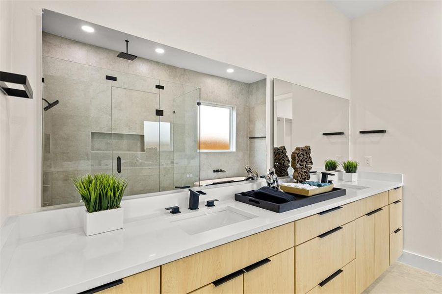 Bathroom featuring a dual vanity with light-toned cabinetry and white countertops