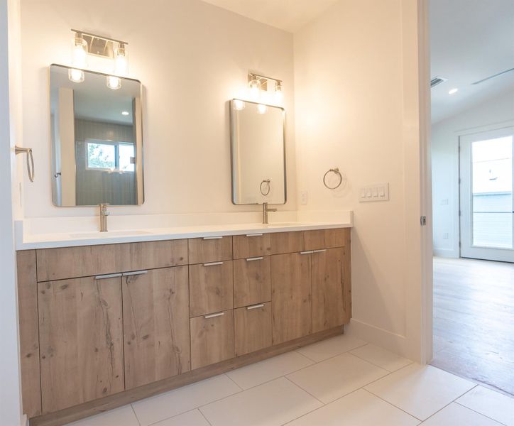 A well-appointed primary bathroom features a dual vanity with ample storage and sleek rectangular mirrors. A well-appointed primary bathroom features a dual vanity with ample storage and sleek rectangular mirrors.