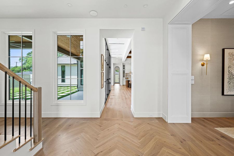 An inviting welcome with light-filled spaces. The entry is defined by soaring 23’ ceilings & a dramatic sense of scale. Herringbone-patterned white oak flooring anchors the space, while a wide staircase w/ wood handrail & iron balusters creates a sculptural focal point. 11’ first floor ceilings throughout first floor. This home is equipped with two tankless water heaters and smart home features. An inviting welcome with light-filled spaces. The entry is defined by soaring 23’ ceilings & a dramatic sense of scale. Herringbone-patterned white oak flooring anchors the space, while a wide staircase w/ wood handrail & iron balusters creates a sculptural focal point. 11’ first floor ceilings throughout first floor. This home is equipped with two tankless water heaters and smart home features.
