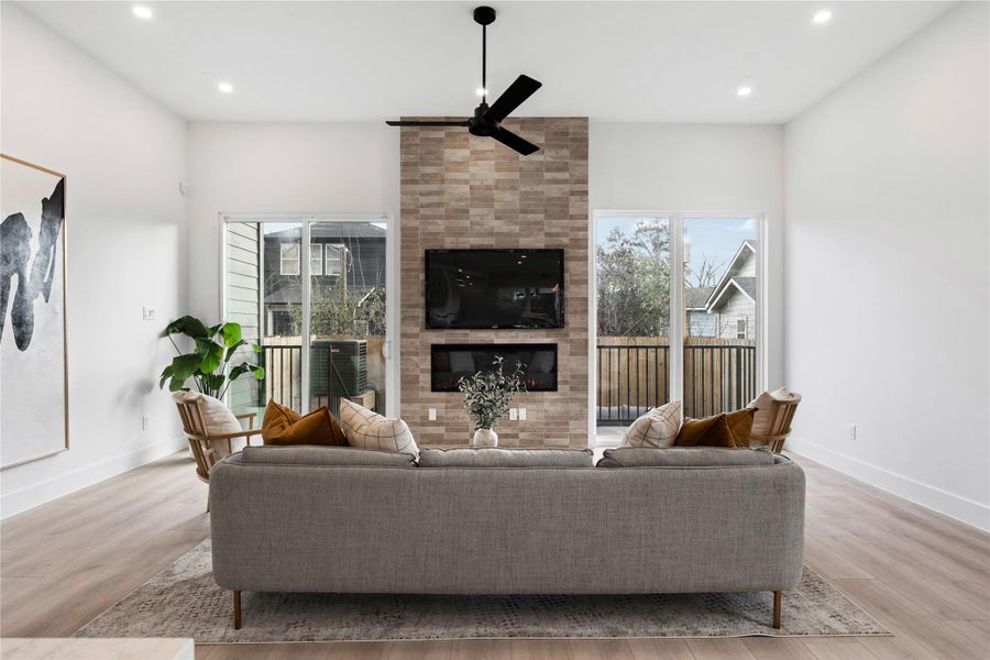 The statement fireplace wall commands attention while natural light pours in from either side. With effortless flow to the balcony beyond, the room feels open, refined, and ready to be lived in.