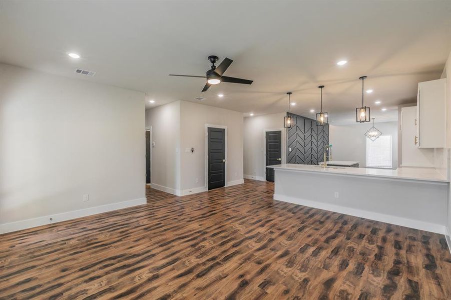 Unfurnished living room with dark hardwood / wood-style flooring and ceiling fan