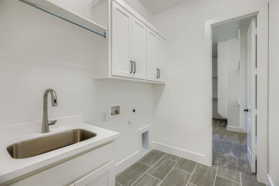 Laundry room with cabinet space, hookup for an electric dryer, hookup for a washing machine, and gas dryer hookup