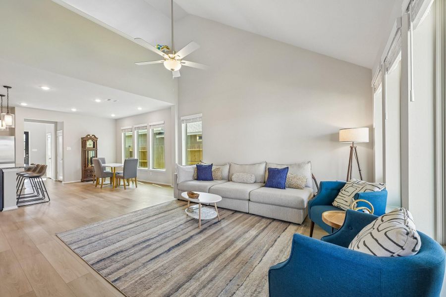 Spacious open-concept living area with abundant natural light, featuring modern furnishings and a cozy seating arrangement, seamlessly connected to the dining space and kitchen.