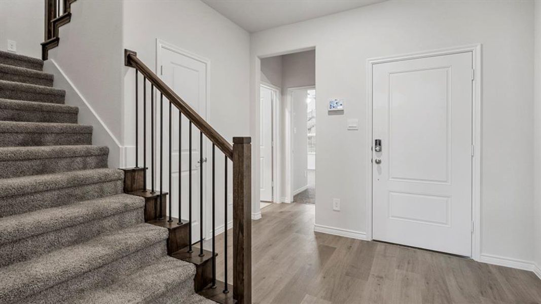 Foyer with stairs and light wood-style flooring Foyer with stairs and light wood-style flooring